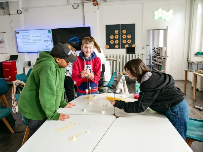 Kinder beim Turmbauen mit Marshmallows und Spaghettis